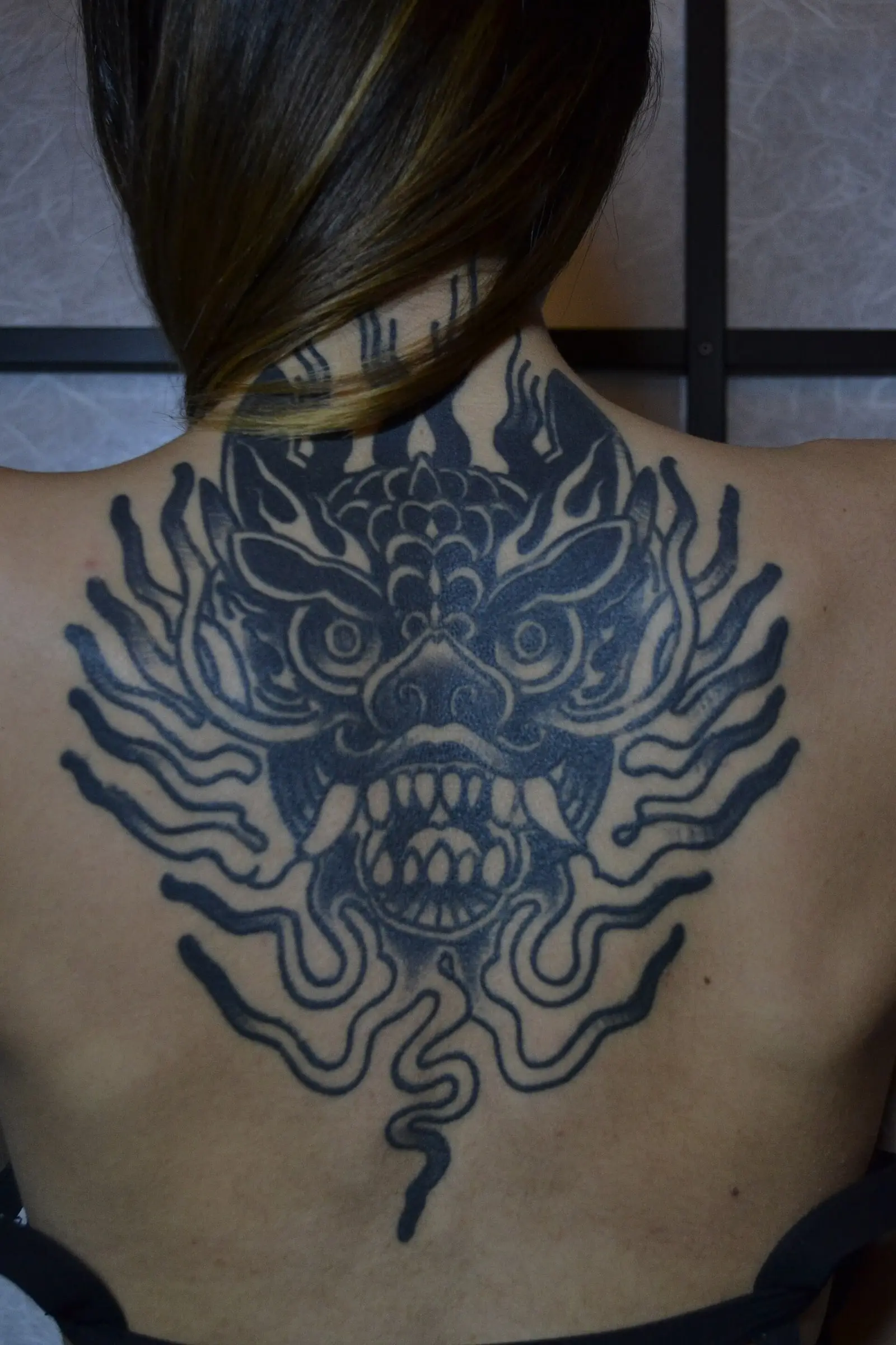 Grande pièce blackwork dans le dos, réalisée au studio Noir d'Encre