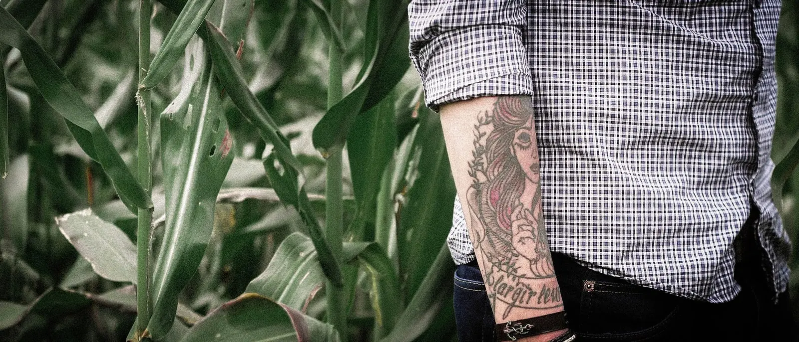 Ligne fine tatouée sur l'avant-bras dans la végétation