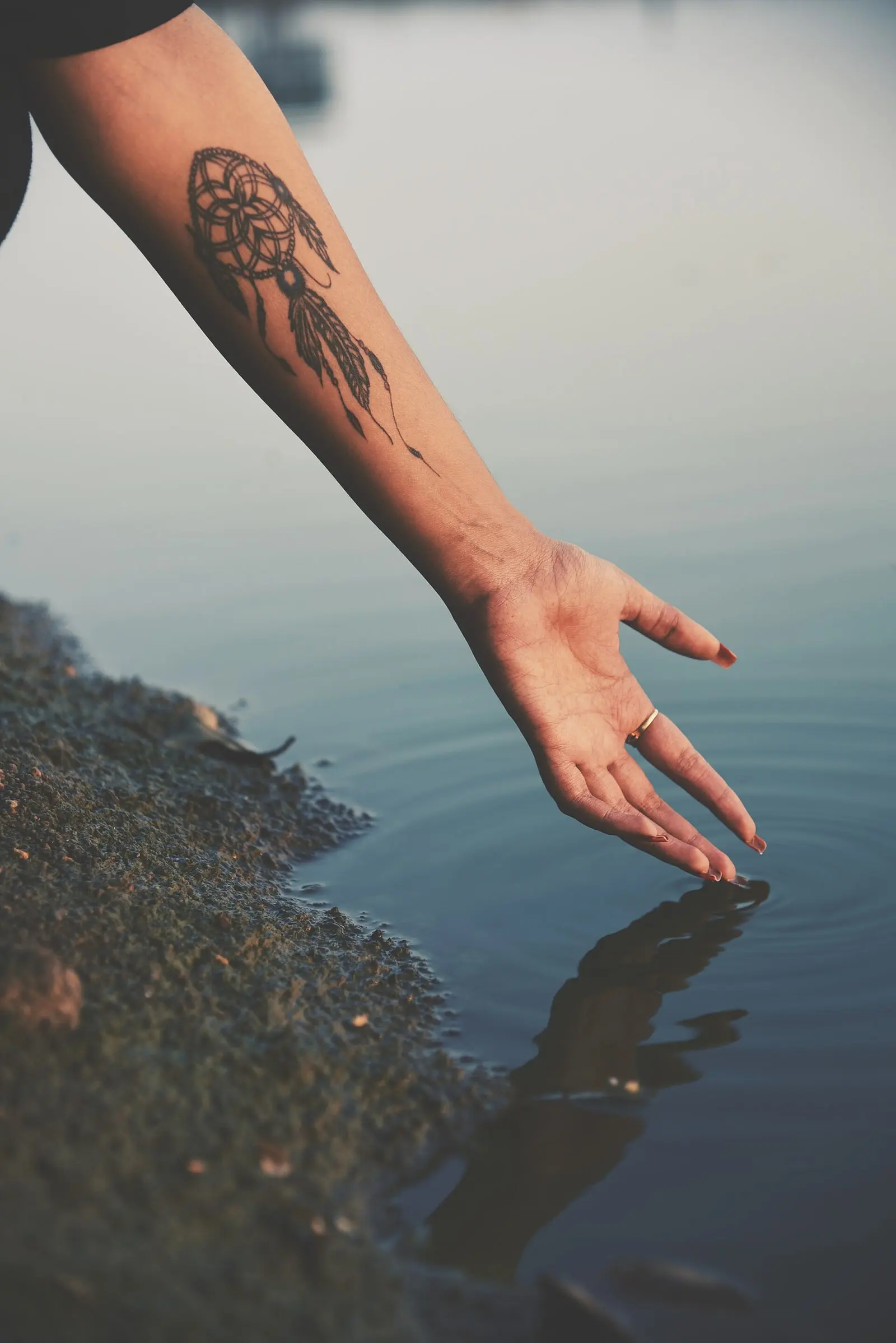 Tatouage fine line sur un bras au-dessus de l'eau