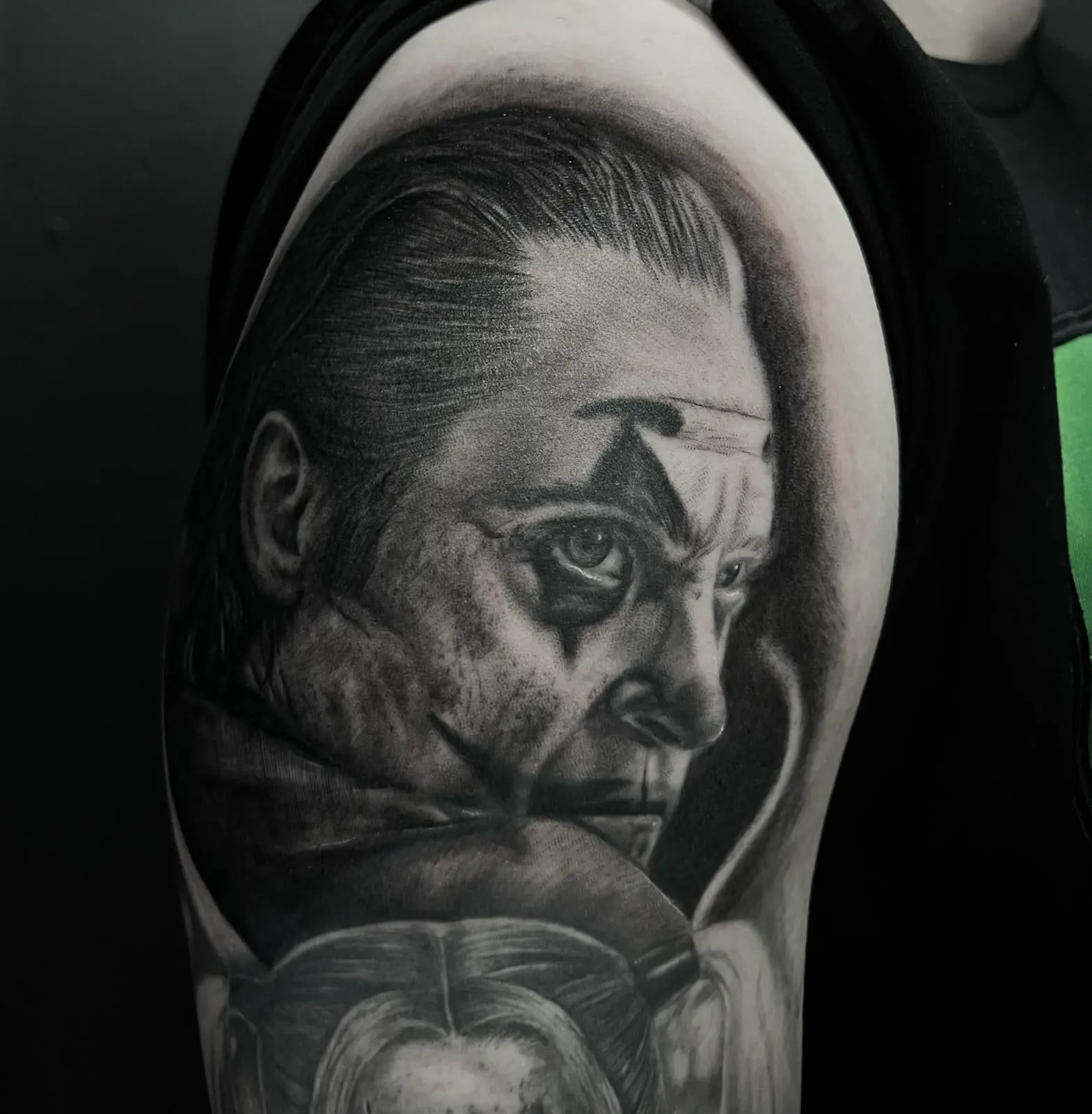 Portrait réaliste noir et gris tatoué sur le bras