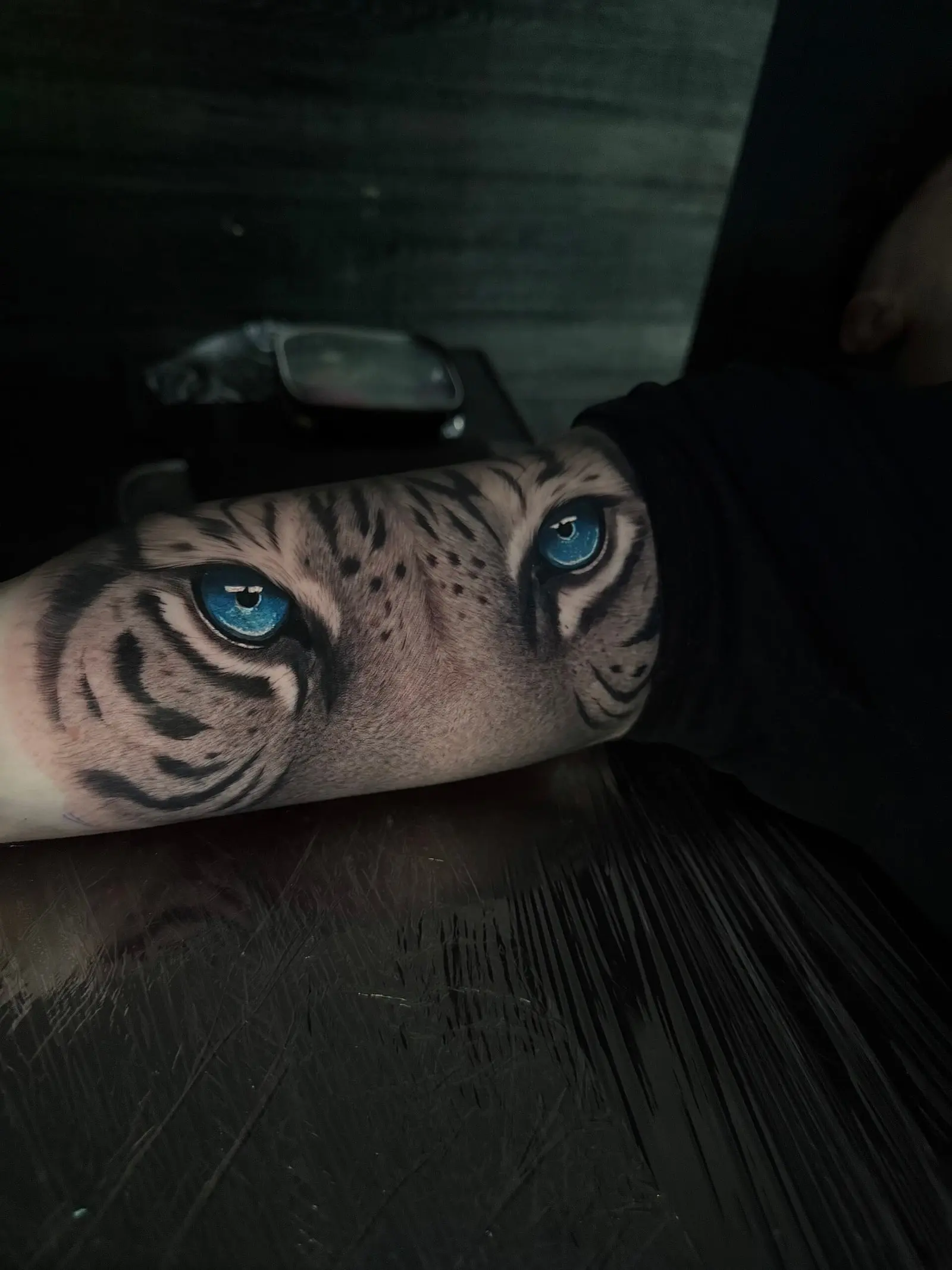 Regard de tigre tatoué en réalisme sur l'avant-bras